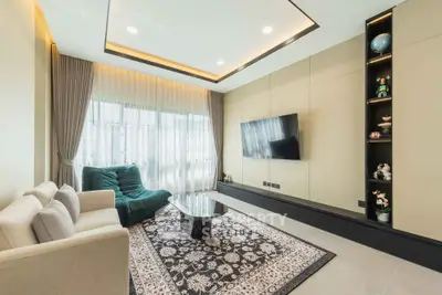 Modern living room with elegant decor, featuring a plush sofa, stylish armchair, and wall-mounted TV.