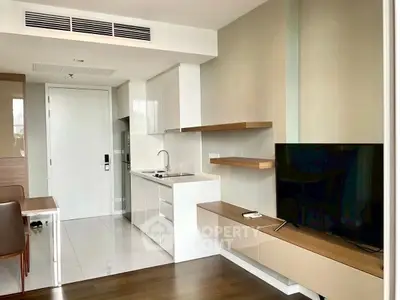 Modern apartment living room with sleek kitchen and wall-mounted TV