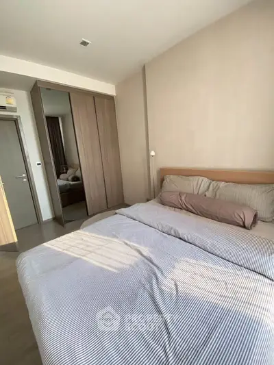 Cozy bedroom with modern design and ample natural light, featuring a comfortable bed and built-in wardrobe.