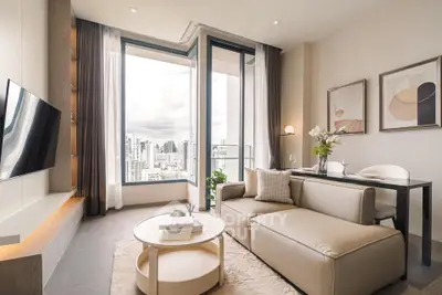 Modern living room with city view, stylish decor, and cozy seating area in a high-rise apartment.