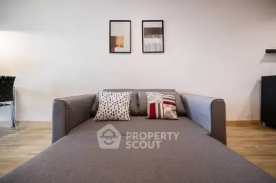 Modern living room with stylish gray sofa and decorative pillows, perfect for relaxation.