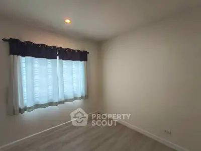 Spacious empty room with large window and elegant curtains, perfect for customization.