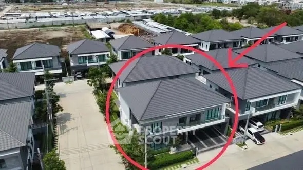 Aerial view of modern residential houses with spacious driveways and lush greenery.