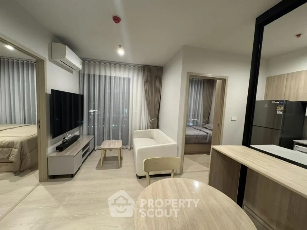 Modern living room with open kitchen and cozy bedroom view