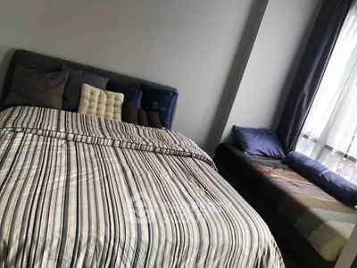 Cozy bedroom with striped bedding and large window for natural light.