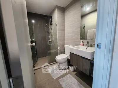 Modern bathroom with sleek design, glass shower, and stylish fixtures.