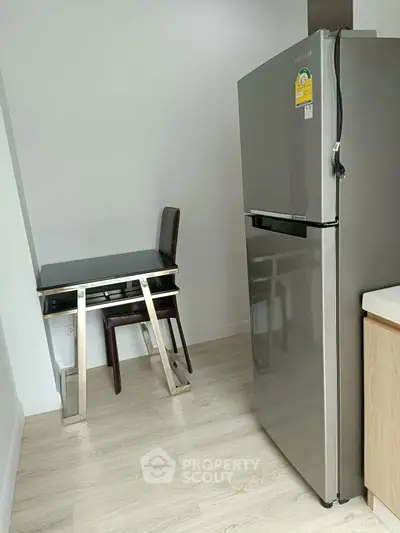 Modern kitchen corner with sleek fridge and compact dining area