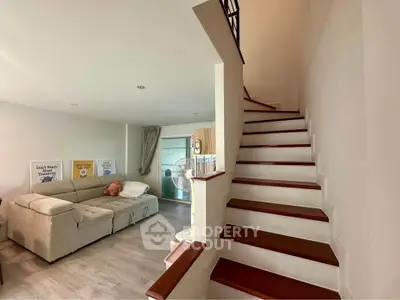 Spacious living room with modern staircase and cozy seating area