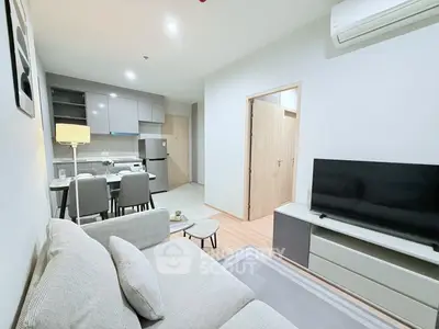 Modern open-plan living room with sleek kitchen and cozy seating area