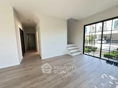 Spacious modern living area with large windows and wooden flooring