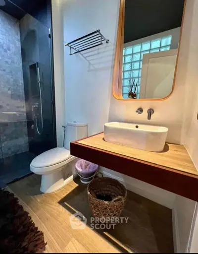 Modern bathroom with sleek design, featuring a stylish sink, toilet, and spacious shower area.