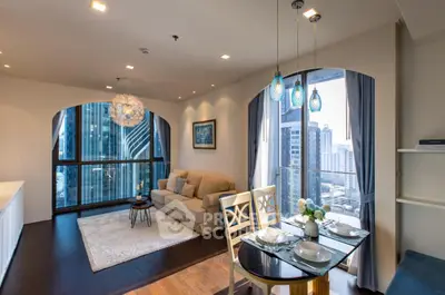 Elegant high-rise corner unit with expansive windows offering a panoramic city view, featuring a cozy living space with modern furnishings and chic pendant lighting.