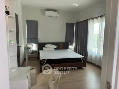 Spacious bedroom with modern furnishings and natural light