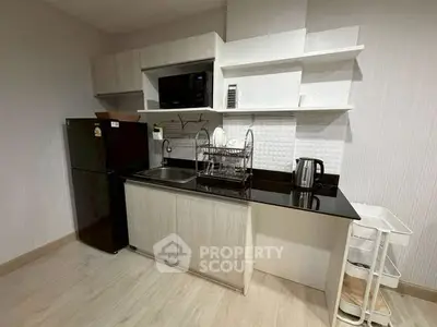 Modern compact kitchen with sleek appliances and open shelving in a stylish apartment.