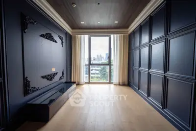 Luxurious empty room with elegant paneling and large window offering city view
