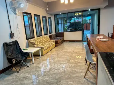 Spacious living room with modern furniture and large windows overlooking driveway