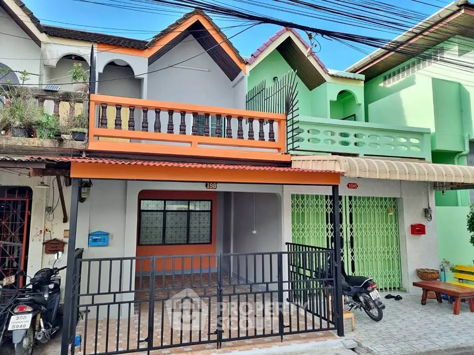 Charming townhouse with colorful facade and gated entrance in a vibrant neighborhood.