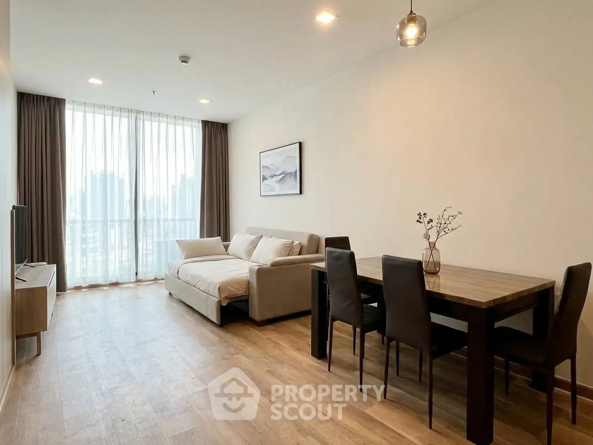 Spacious modern living room with large windows and elegant dining area