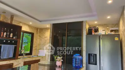 Luxurious modern kitchen with marble walls and stainless steel appliances, perfect for culinary enthusiasts.
