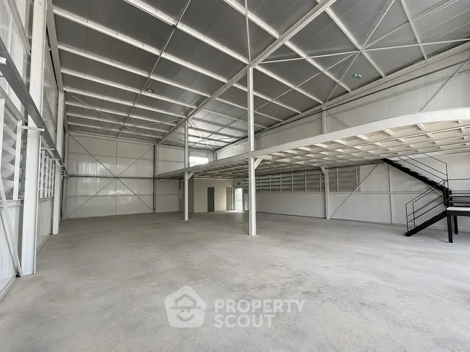 Spacious industrial warehouse with mezzanine and high ceilings, ideal for storage or manufacturing.