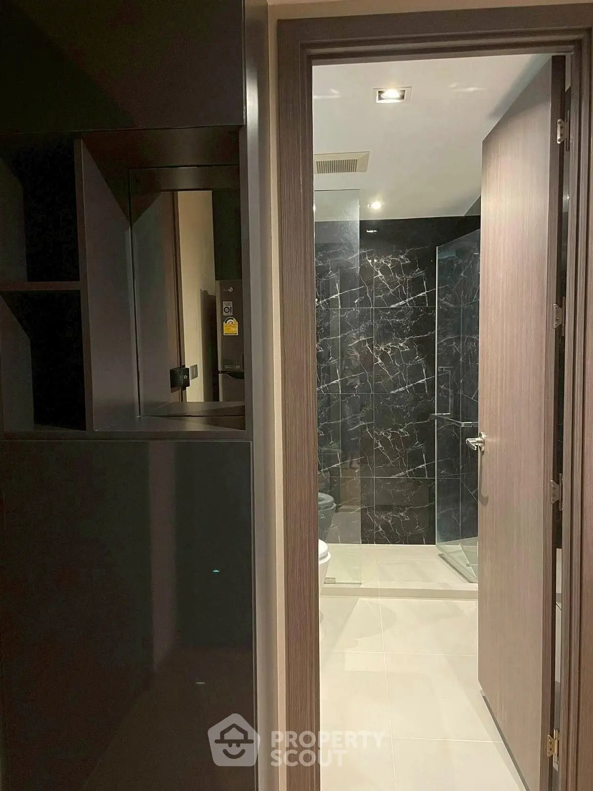 Modern bathroom with sleek black marble tiles and glass shower enclosure