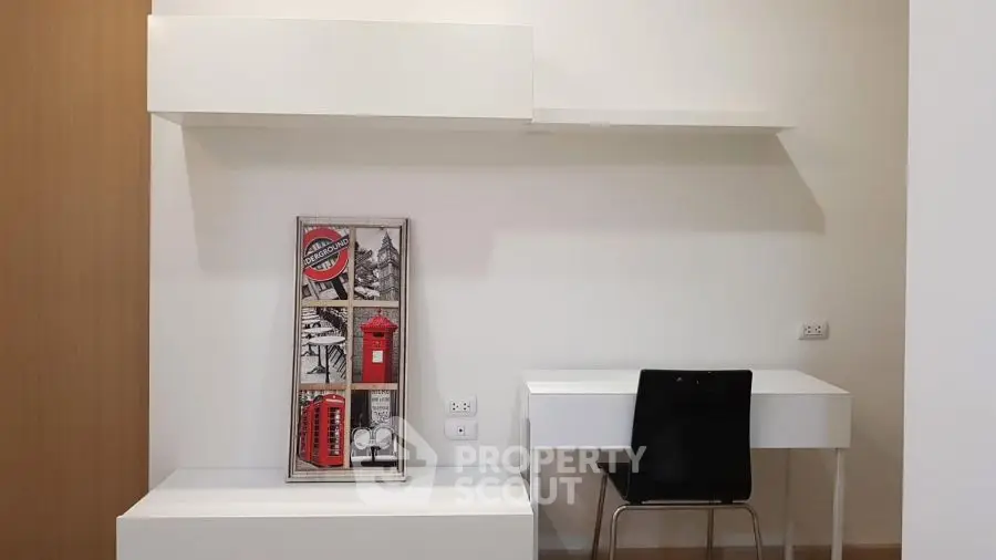 Modern study area with sleek white desk and chair, featuring stylish wall art.