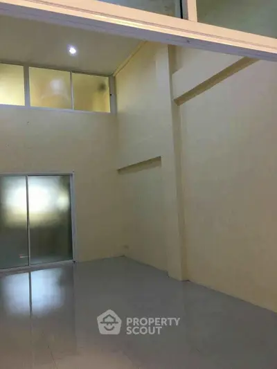 Spacious interior with high ceilings and frosted glass doors, ideal for modern living.