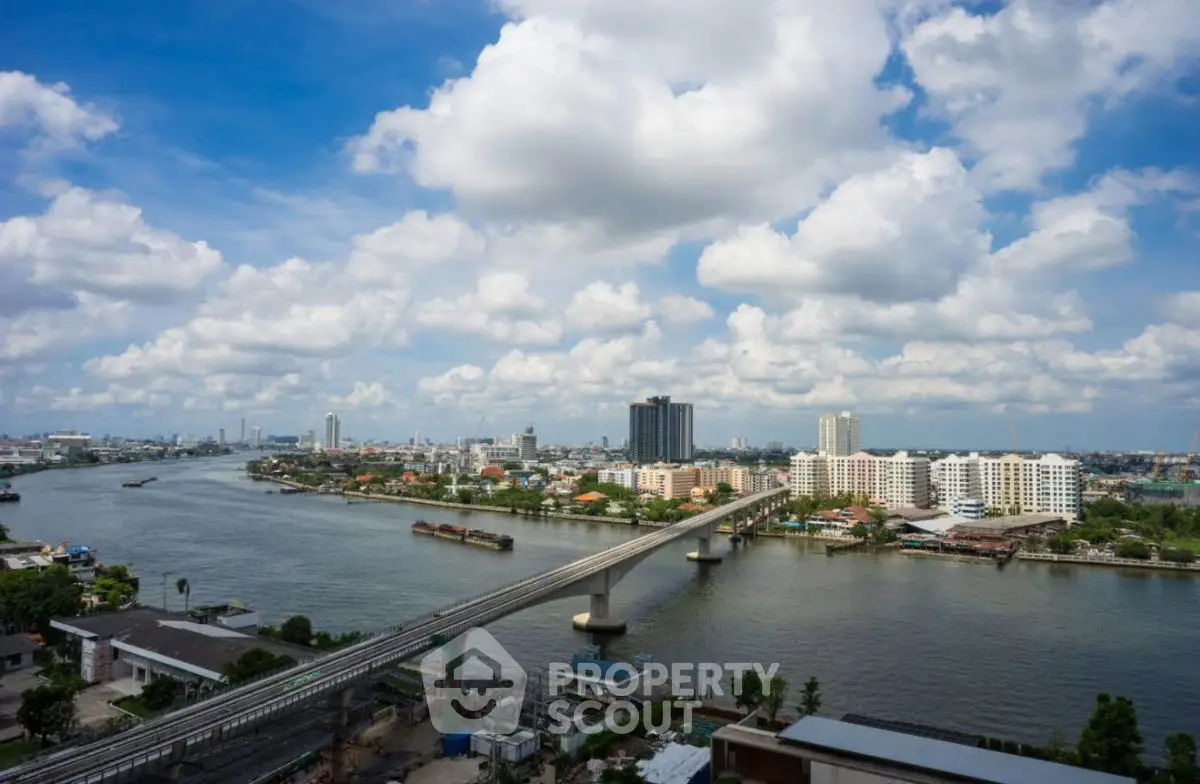 Stunning cityscape view with river and bridge under a vibrant blue sky.