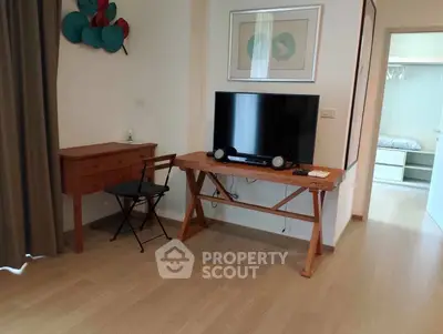 Modern living room with wooden flooring, stylish furniture, and a flat-screen TV for a cozy ambiance.
