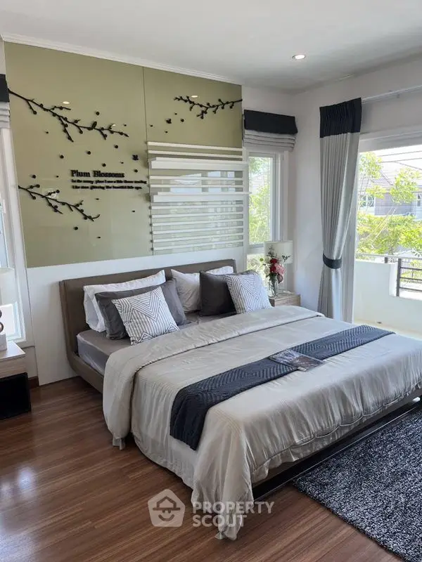 Elegant bedroom with modern decor and large windows offering natural light