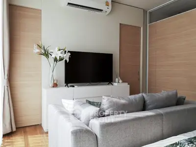 Modern living room with sleek gray sofa and wall-mounted TV