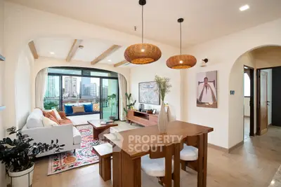 Spacious living room with modern decor and city view, featuring wooden dining table and cozy seating area.