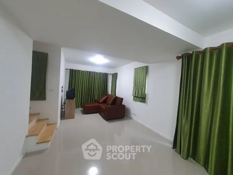 Spacious living room with modern decor and green curtains