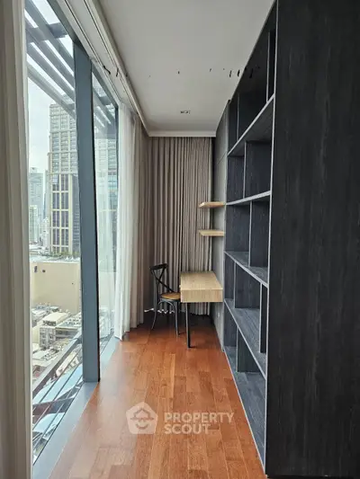 Modern study room with floor-to-ceiling windows and city view, featuring sleek shelving and wooden flooring.