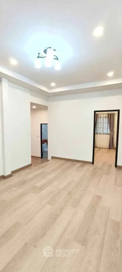 Spacious empty living room with modern lighting and wood flooring