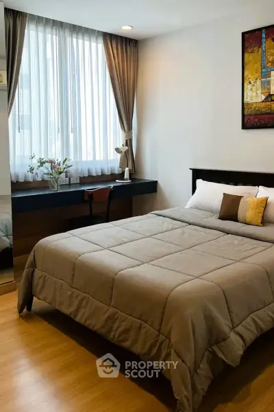 Cozy bedroom with large window and stylish decor in modern apartment.
