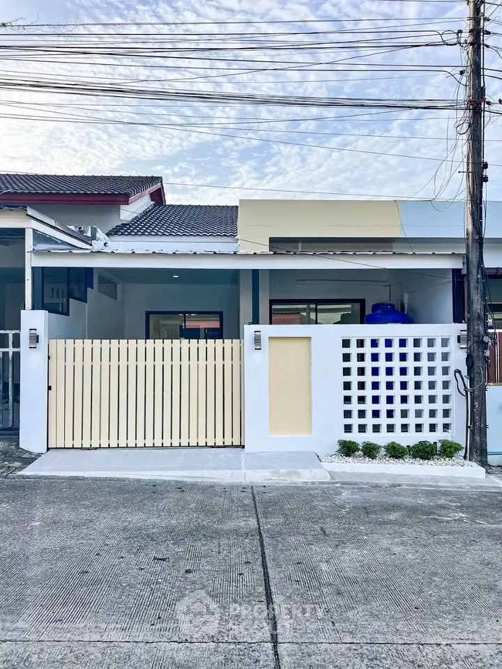 Charming single-story home with modern facade and gated entrance in a serene neighborhood.