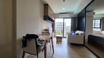 Modern studio apartment with open layout, featuring a cozy living area and balcony view.