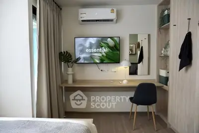 Modern bedroom with stylish decor, featuring a wall-mounted TV and sleek workspace.