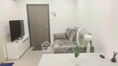 Cozy living room with modern sofa and TV setup, perfect for relaxation.