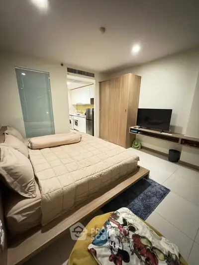 Cozy bedroom with modern decor and open kitchen layout in a stylish apartment.