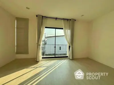 Spacious empty room with large window and balcony view, perfect for customization.