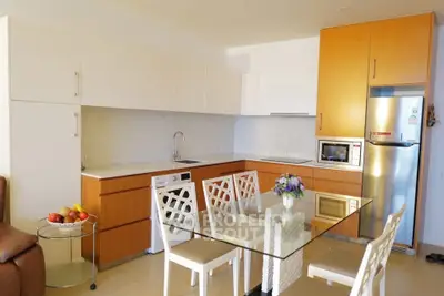 Modern kitchen with sleek cabinets and glass dining table in a bright open space.