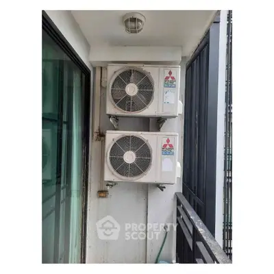 Modern balcony with dual air conditioning units in urban apartment setting.