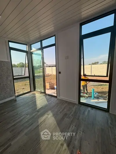 Modern interior with large windows and stylish flooring, offering a bright and airy atmosphere.