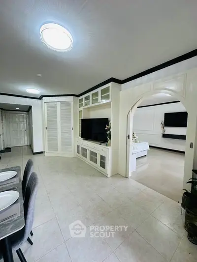 Spacious open-plan living area with modern decor and built-in entertainment unit.