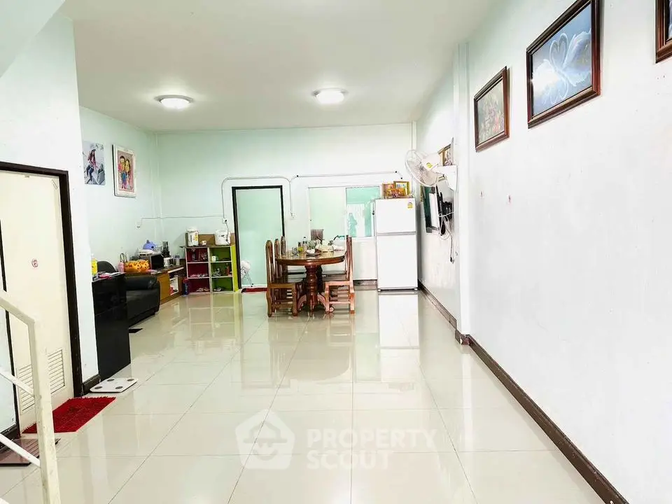 Spacious open-plan living and dining area with modern decor and tiled flooring.