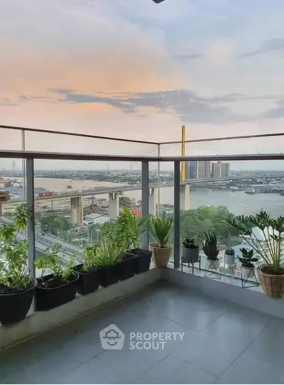 Stunning balcony with panoramic river view and lush greenery.