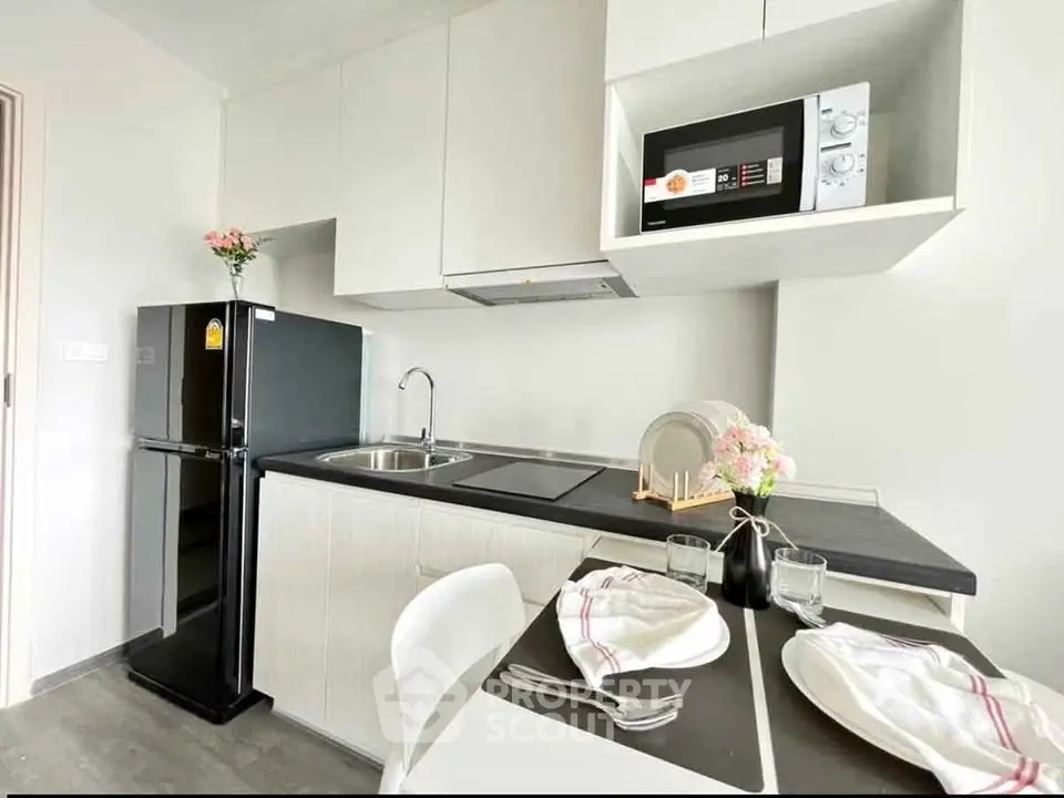 Modern kitchen with sleek appliances and dining setup in a stylish apartment.