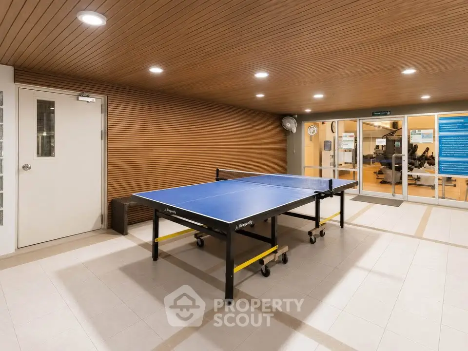 Modern indoor recreational area with ping pong table and stylish wood paneling.